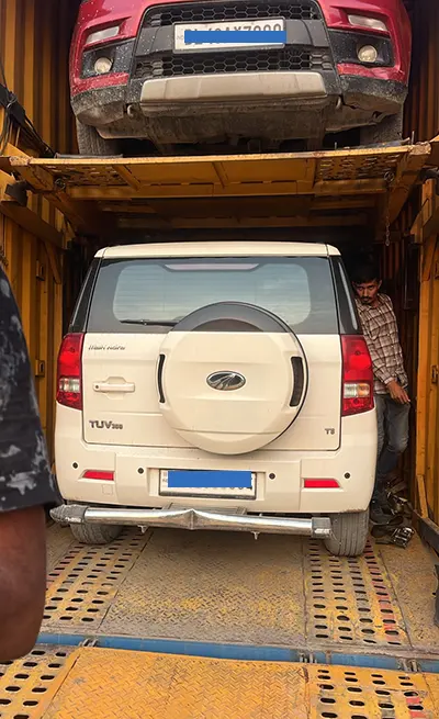 Professional car loading onto a secure multi-level carrier in 